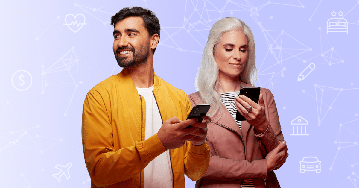 A man and a woman smiling and holding mobile devices for digital identity verification