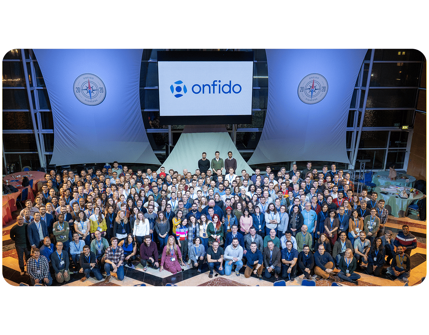 Una foto corporativa de Onfido con cientos de empleados.